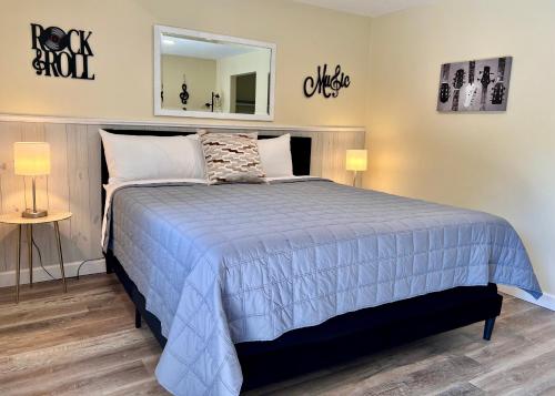 a bedroom with a bed with a blue comforter and a mirror at Green Acre Motel in Lake George