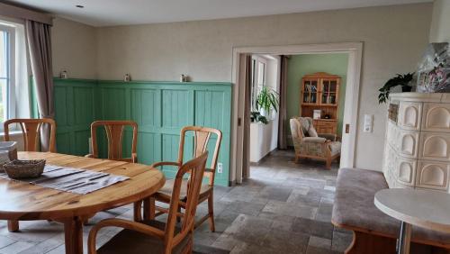 a dining room with a wooden table and chairs at Rosenberghof in Hillesheim