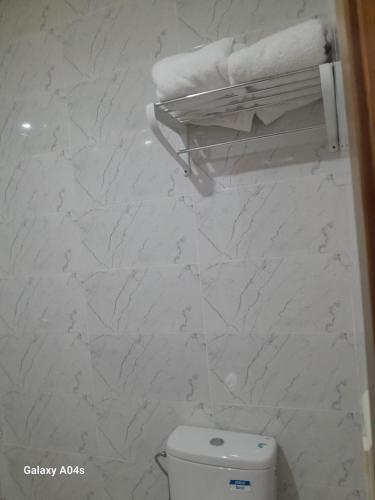 a bathroom with a toilet and towels on a wall at Central in Agadir