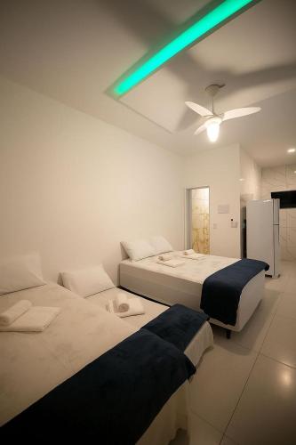 a bedroom with two beds and a green light at Pousada encanto do sol in Búzios