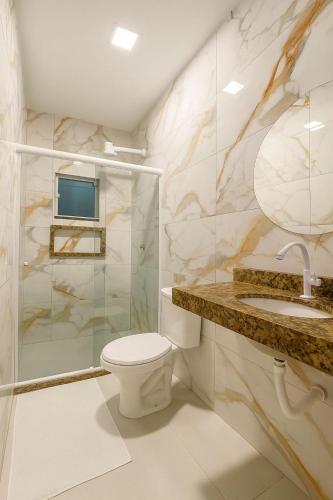 a bathroom with a toilet and a shower and a sink at Pousada encanto do sol in Búzios