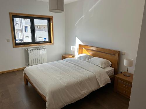 a bedroom with a large bed and a window at Apartamento Braguinha in Bragança