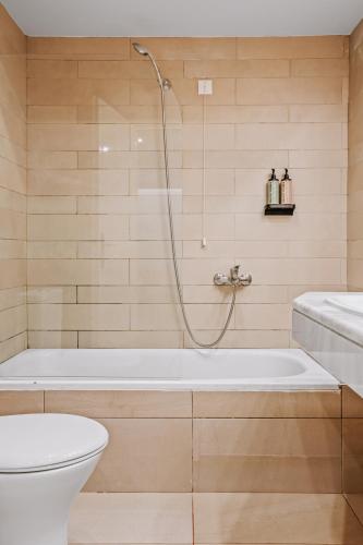 a bathroom with a tub and a toilet and a shower at Almyra Resort in Koutsounari