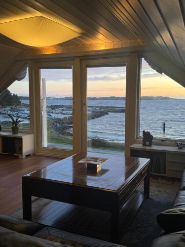 a living room with a coffee table in front of windows at Flott leilighet med fantastisk utsikt in Stavanger