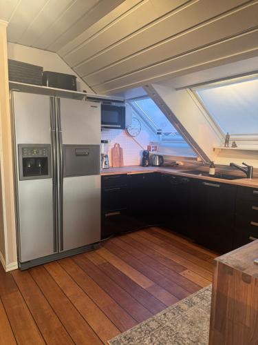 una cucina con frigorifero in acciaio inossidabile al centro di Flott leilighet med fantastisk utsikt a Stavanger