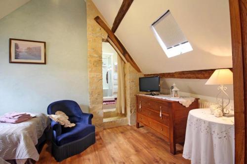 a bedroom with a bed and a chair and a desk at Au bord de l'Huisne in Saint-Germain-des-Grois