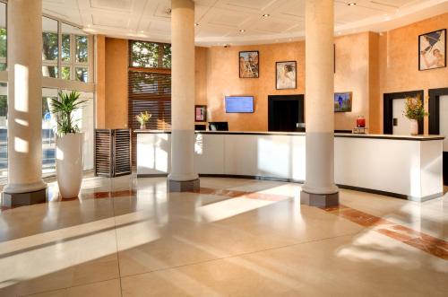 an office lobby with columns and a reception desk at Mercure Montpellier Centre Antigone in Montpellier