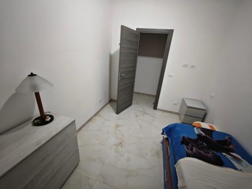 a room with a bed and a table and a lamp at Genova Metro Apartment in Genova