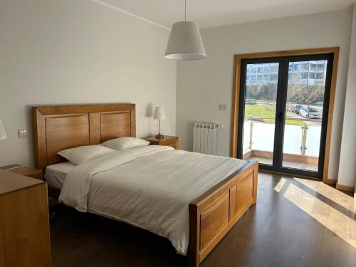 a bedroom with a large bed and a large window at Apartamento Braguinha in Bragança