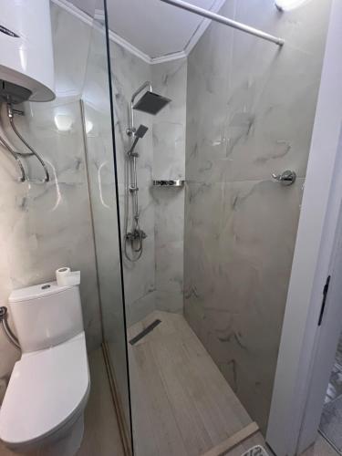 a bathroom with a shower with a toilet and a glass door at royal room in Ulcinj