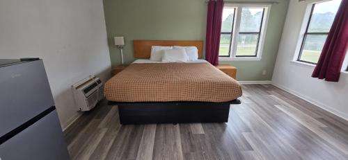 a bedroom with a bed with a wooden floor at white columns motel in Pine Mountain