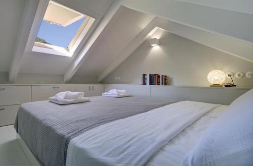 una camera da letto con un letto grande con due asciugamani sopra di Limone Loft cottage Ithaka a Perakhórion