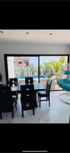a dining room with a table and chairs and a large window at Villa Solara in Kelibia