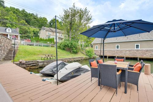 a wooden deck with a table and an umbrella at Recently Renovated Harveys Lake Retreat with Dock! in Harveys Lake