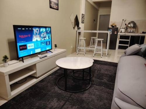 a living room with a tv and a table at Firza Suite in Gua Sai