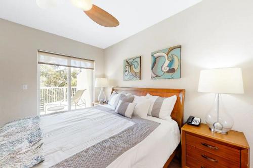 a white bedroom with a bed and a window at Salty Daze at Crystal Palms in St Pete Beach