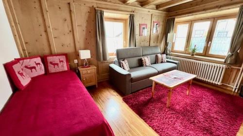 a living room with a couch and a table at Hotel Chasa Sofia in Scuol