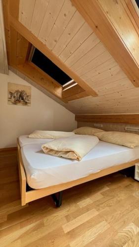 a bed in a room with an attic at Hotel Chasa Sofia in Scuol