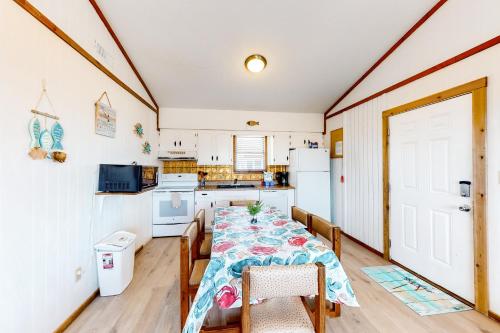 a dining room with a table and a kitchen at Tower Top & Bottom in Buxton