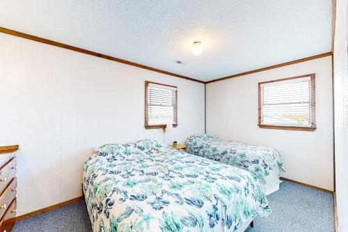 a bedroom with two beds and two windows at Tower Top & Bottom in Buxton
