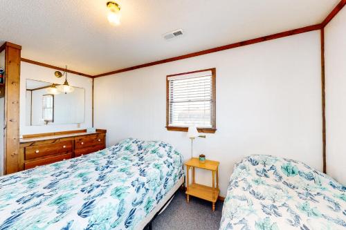 a bedroom with two beds and a dresser and a mirror at Tower Top & Bottom in Buxton