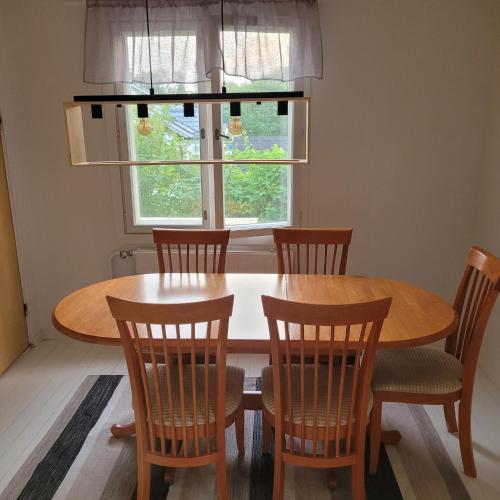 a dining room table with chairs and a window at A great choice! Wooden sauna, pool table, 3BR, 2 toilet, 2 bathrooms in Oulu