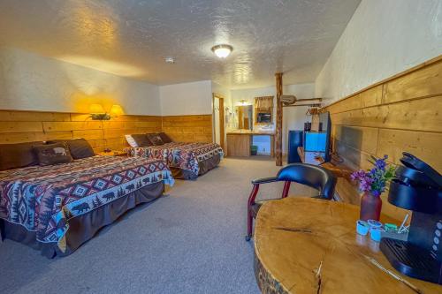 a hotel room with two beds and a desk at Chinook Winds Lodge in Dubois