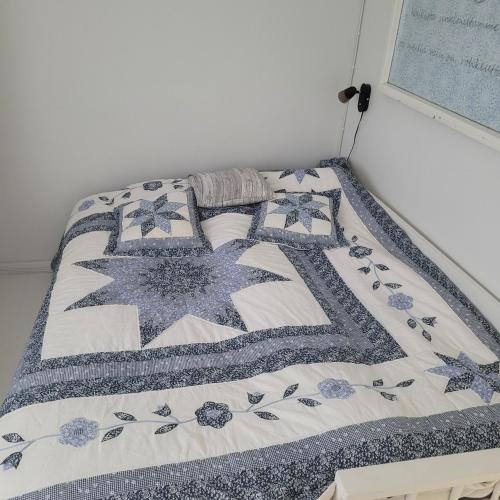 a bed with a blue and white quilt on it at A great choice! Wooden sauna, pool table, 3BR, 2 toilet, 2 bathrooms in Oulu