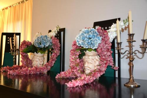 a table with two vases filled with flowers on it at Villa Luisa Design in Colle Val D'Elsa