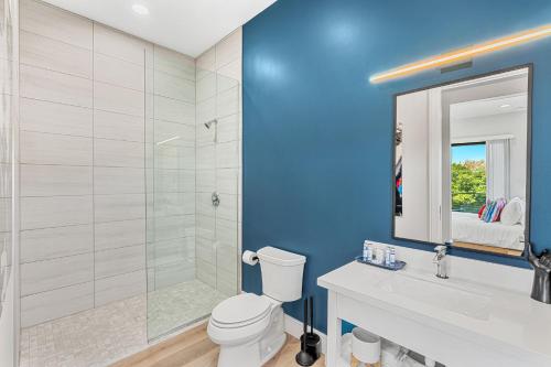 a bathroom with a shower and a toilet and a sink at Wave Haven Suites - 4BR-5BA Luxury - 2 Suites - Walk to Beach - Views in Cocoa Beach