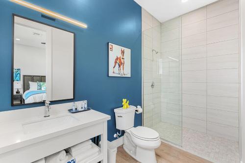 a bathroom with a white toilet and a shower at Wave Haven Suites - 4BR-5BA Luxury - 2 Suites - Walk to Beach - Views in Cocoa Beach