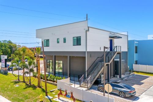 a house with a car parked in front of it at Wave Haven Suites - 4BR-5BA Luxury - 2 Suites - Walk to Beach - Views in Cocoa Beach