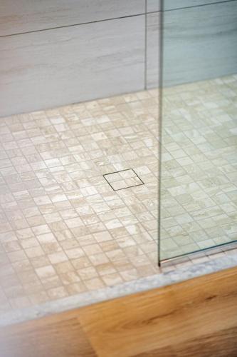 a room with a tile floor and a glass wall at Wave Haven Suites - 4BR-5BA Luxury - 2 Suites - Walk to Beach - Views in Cocoa Beach