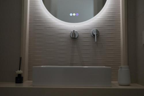 a bathroom with a white sink and a mirror at DR Luxury Apartments in Avola