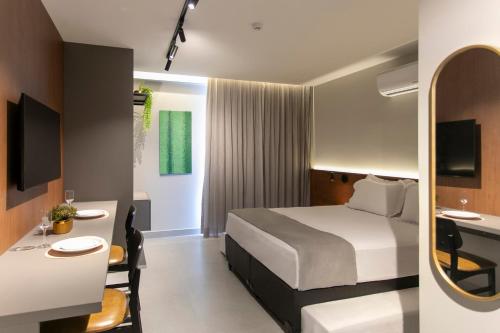a hotel room with a bed and a desk at Simple Smart By Xtay - Novo, aconchegante e a 7min do Manaíra Shopping in João Pessoa