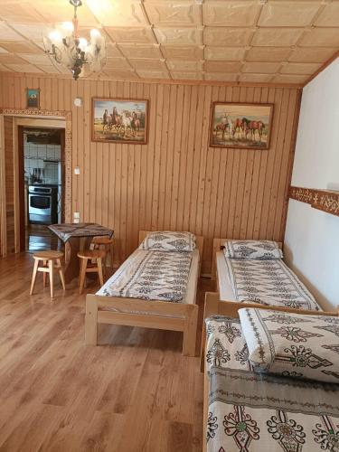 a room with three beds and a table in it at Pokoje gościnne u Krupy in Murzasichle