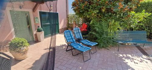 two blue chairs and a bench on a patio at Il Nido Rustico in Ponsacco