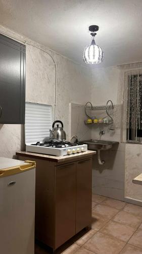 a kitchen with a stove with a tea kettle on it at tata's house in Kobuleti