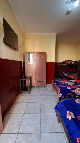 a room with two beds and a flat screen tv at Hospedaje Artigas in Corrientes