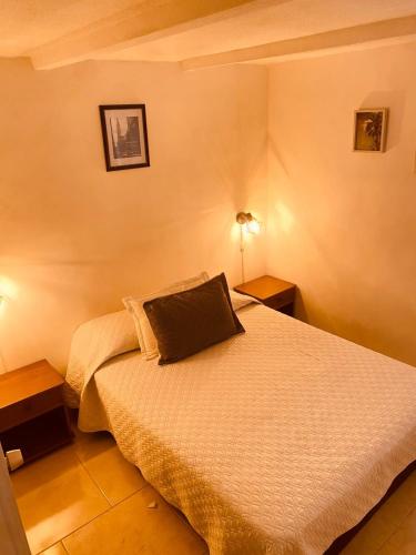a bedroom with a bed with two night stands and two lamps at Casa de Descanso en Medellín in Medellín