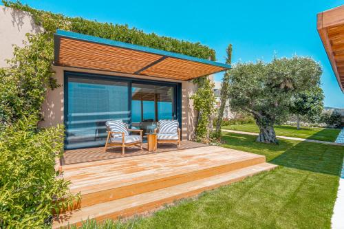 a deck with two chairs and a table in a yard at Villa Kaplankaya in Milas