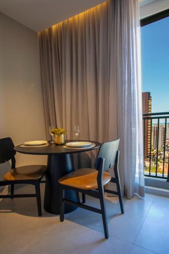 a dining room with a table and chairs and a window at Simple Smart By Xtay - Novo, aconchegante e a 7min do Manaíra Shopping in João Pessoa