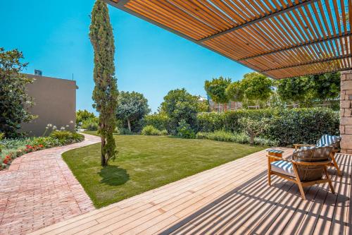 a wooden patio with a bench and a garden at Villa Kaplankaya in Milas