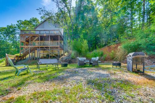 a house with a picnic table and benches in the yard at Lakefront Retreat with Multi-Level Deck and Dock! in Alexander