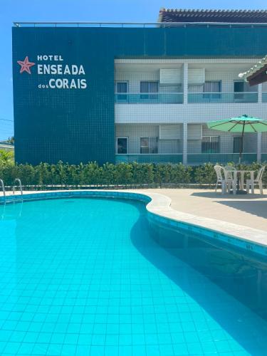 a swimming pool in front of a hotel in front of a building at Hotel Enseada dos Corais in Cabo de Santo Agostinho