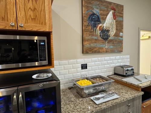 a kitchen with a rooster painting on the wall at Western Budget Motel Leduc #3 in Leduc