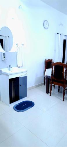a bathroom with a sink and a mirror on the floor at Alappuzha Family Vacation Villa - LAYANILA in Alleppey