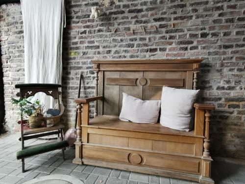 a wooden bed with two pillows and a brick wall at Refugium29a in Horn