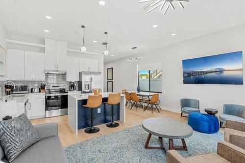an open living room with a kitchen and a dining room at Wave Haven Villas - 2 Luxury Villas - 3BR 3 and a Half BA Each - Sleeps 8 Per Unit - Hot Tub - Across from Beach - Rocket and Beach Views in Cocoa Beach