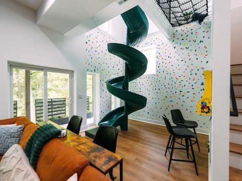 a living room with a spiral staircase in the wall at The Greenhouse with Indoor Slide close to Hocking Hills in South Bloomingville